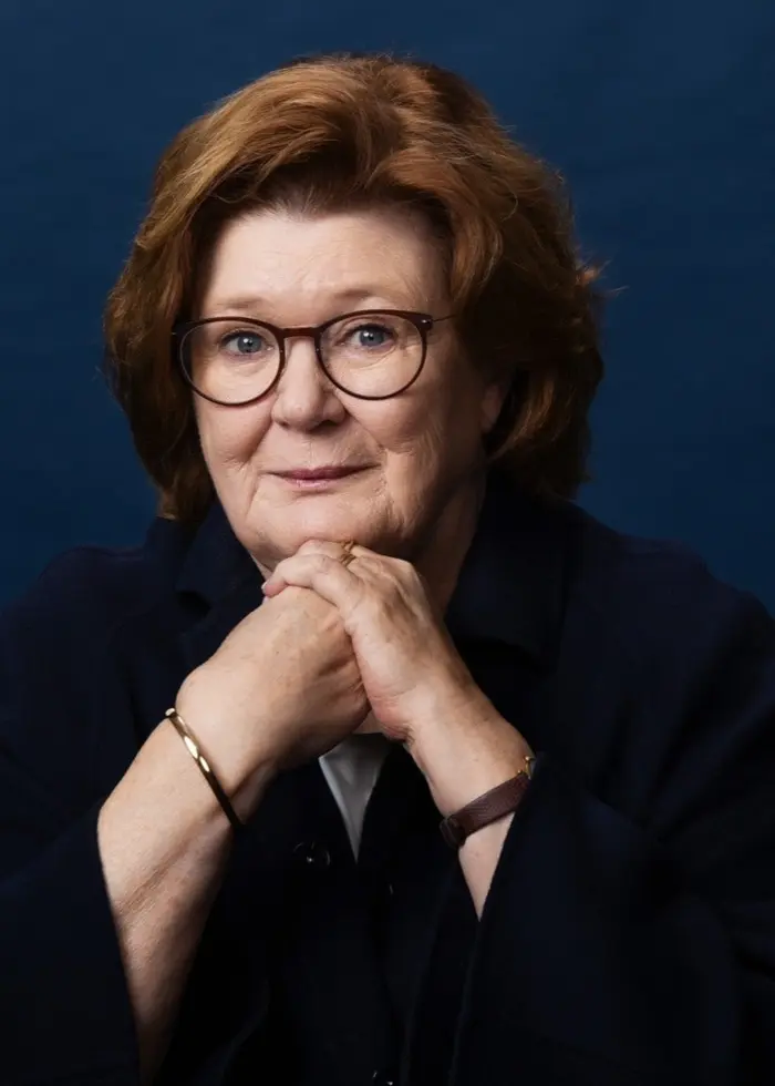 Porträtt på författaren Majgull Axelsson som ser rakt in i kameran och lutar hakan mot händerna.