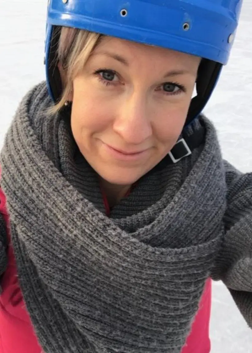 En kvinna med bandyhjälm på en is.