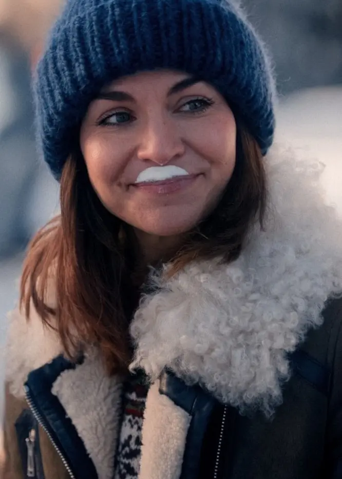 Ida Elise Broch och John Carew ses klädda i vinterkläder under en utomhusscen från norska tv-serien 'Home for Christmas', omgivna av en snötäckt miljö.