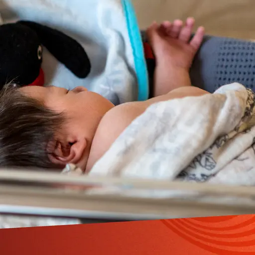 En bebis som ligger i en säng.