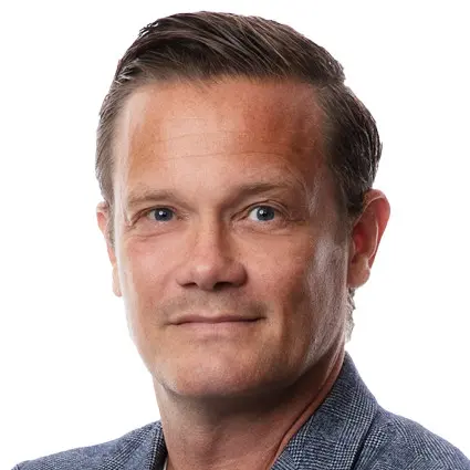 Fotbollsspelare i gula matchdräkter firar på planen efter en match. I förgrunden står en person i grå kavaj med armarna i kors.