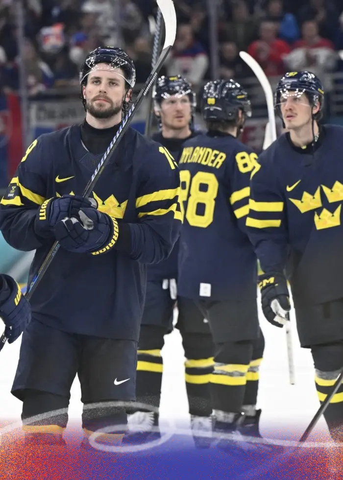 Svenska ishockeyspelare i blåa tröjor med gula kronor står på isen och firar efter en match i OS 2026 i Milano. Spelare som Victor Hedman, Erik Karlsson och Adrian Kempe syns i bild.