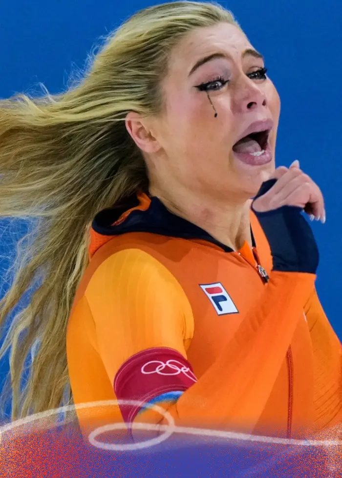 En person klädd i orangea kläder och långt blont hår. Ser ut att ha gråtit.