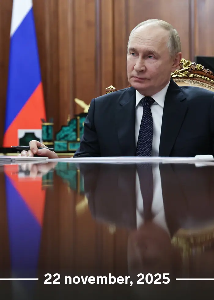 Rysslands president Vladimir Putin deltar i ett säkerhetsrådsmöte via videokonferens från Kreml i Moskva. En stor skärm visar flera deltagare med ryska flaggor i bakgrunden.