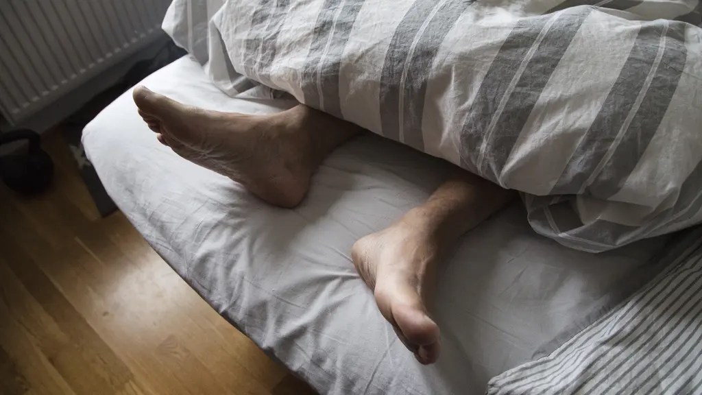 Ett par fötter i en säng
