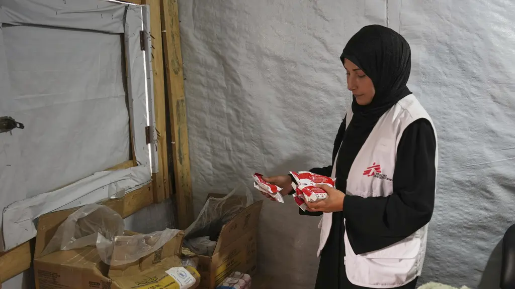 Tre palestinska patienter genomgår dialysbehandling på Al-Aqsa Martyrs-sjukhuset i Deir al-Balah, centrala Gaza. De sitter i en ljus sjukhussal, omgivna av medicinsk utrustning.