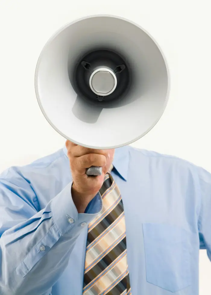 Person håller en megafon framför ansiktet.