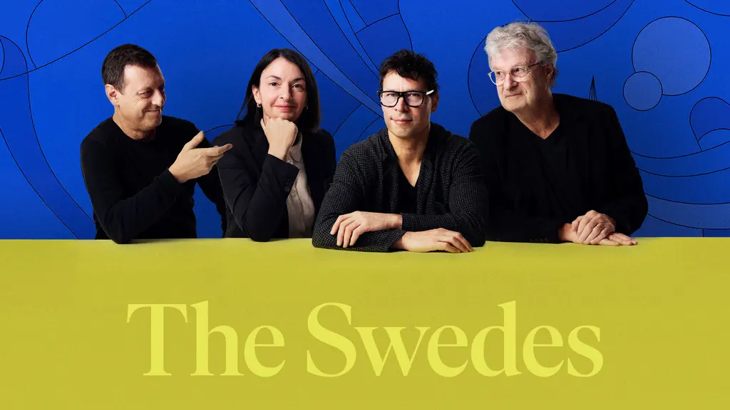 Fyra personer på rad i mörka kläder mot en blå bakgrund.