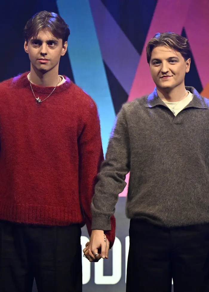 Två personer framför Melodifestivallogga.