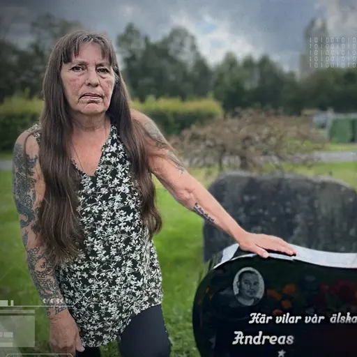 Ulla vid sonen Andreas gravsten, med inskriptionen 'Här vilar vår älskade Andreas' på en kyrkogård omgiven av grönskande träd och gräs. Gravstenen är svart med vit text och dekorerad med hjärtan och blommor. Ulla har långt hår och en svartvit ärmlös blus.