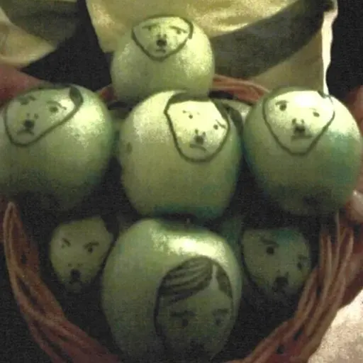 En korg med gröna äpplen där ansikten föreställande Hitler är ritade på frukterna med svart tuschpenna (till vänster). Johan Forssell iförd kostym (till höger).