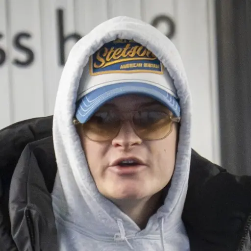 Teckning av en man i vittnesbåset under en rättegång i Oslo tingshus. Personen är klädd i blå skjorta och sitter vid en mikrofon.