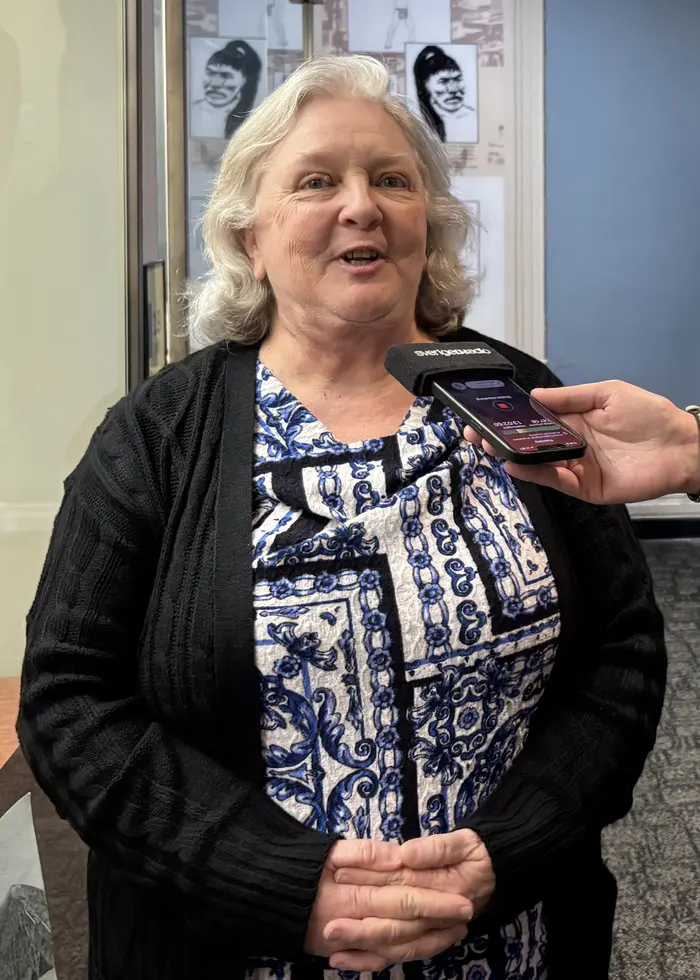 En person står framför en monter med museiföremål i Texarkana. Montern innehåller olika objekt, bilder och dokument. Bakgrunden visar en del av museets interiör med glasmontrar och väggdekorationer.