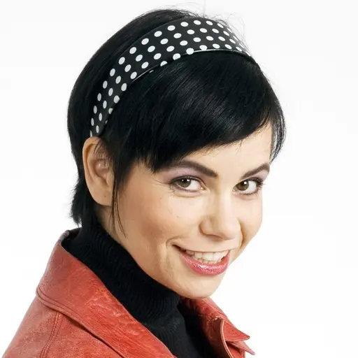 En artist i scenkläder håller en mikrofon i ena handen och en blombukett i den andra efter att ha gått vidare till final i Melodifestivalen 2026 deltävling 2 i Scandinavium, Göteborg.