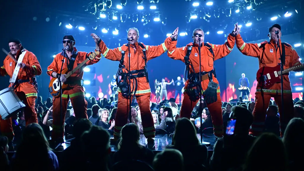 Fem män i orangea brandmanskläder, och en kvinna i grön jacka.