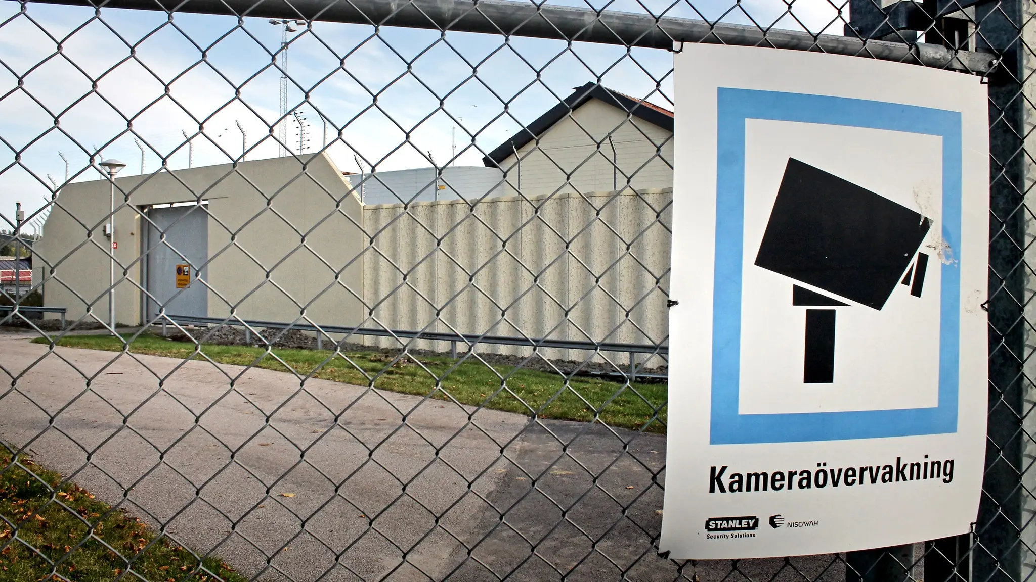 en husfasad bakom stängsel