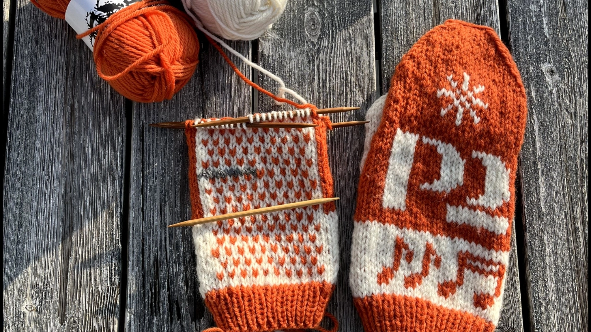 Ett par halvfärdiga stickade vantar 