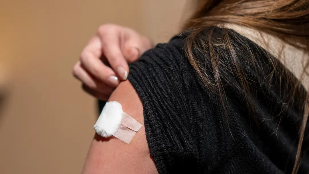 Smittskyddsläkare Johan Nöjd står utanför en byggnad med glasdörrar, iklädd en mörk jacka. Bilden relaterar till en tidig influensasäsong.