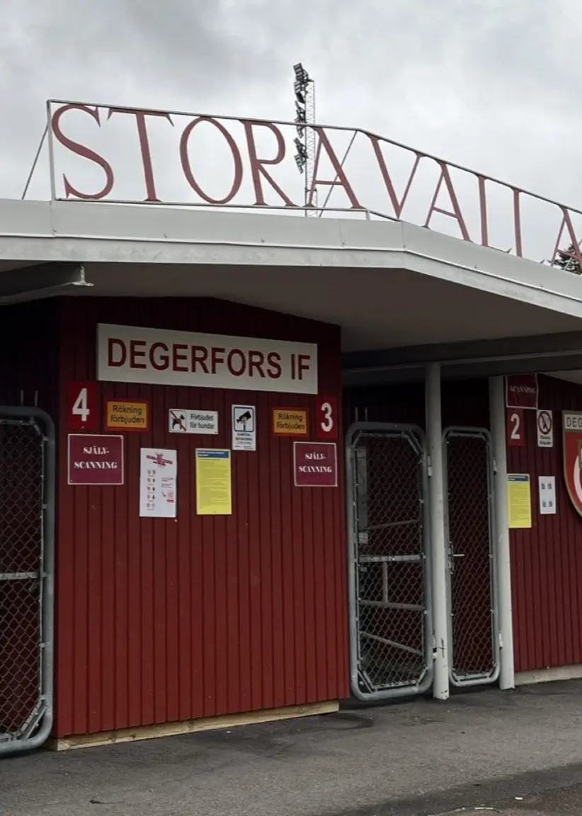 Anneli Mylly (V), kommunstyrelsens ordförande i Degerfors, framför en inomhusmiljö samt entrén till Stora Valla, Degerfors IF:s hemmaarena.