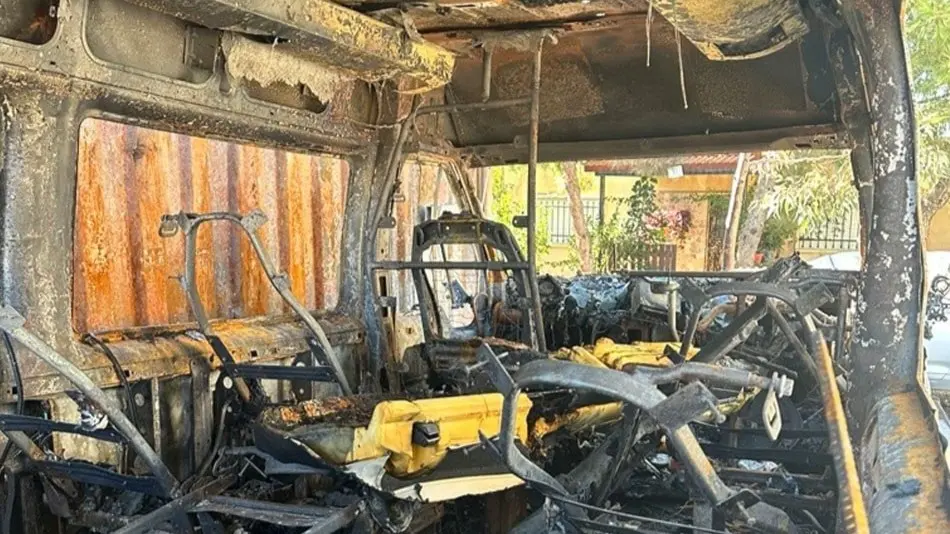 En utbränd buss och en kvinna.