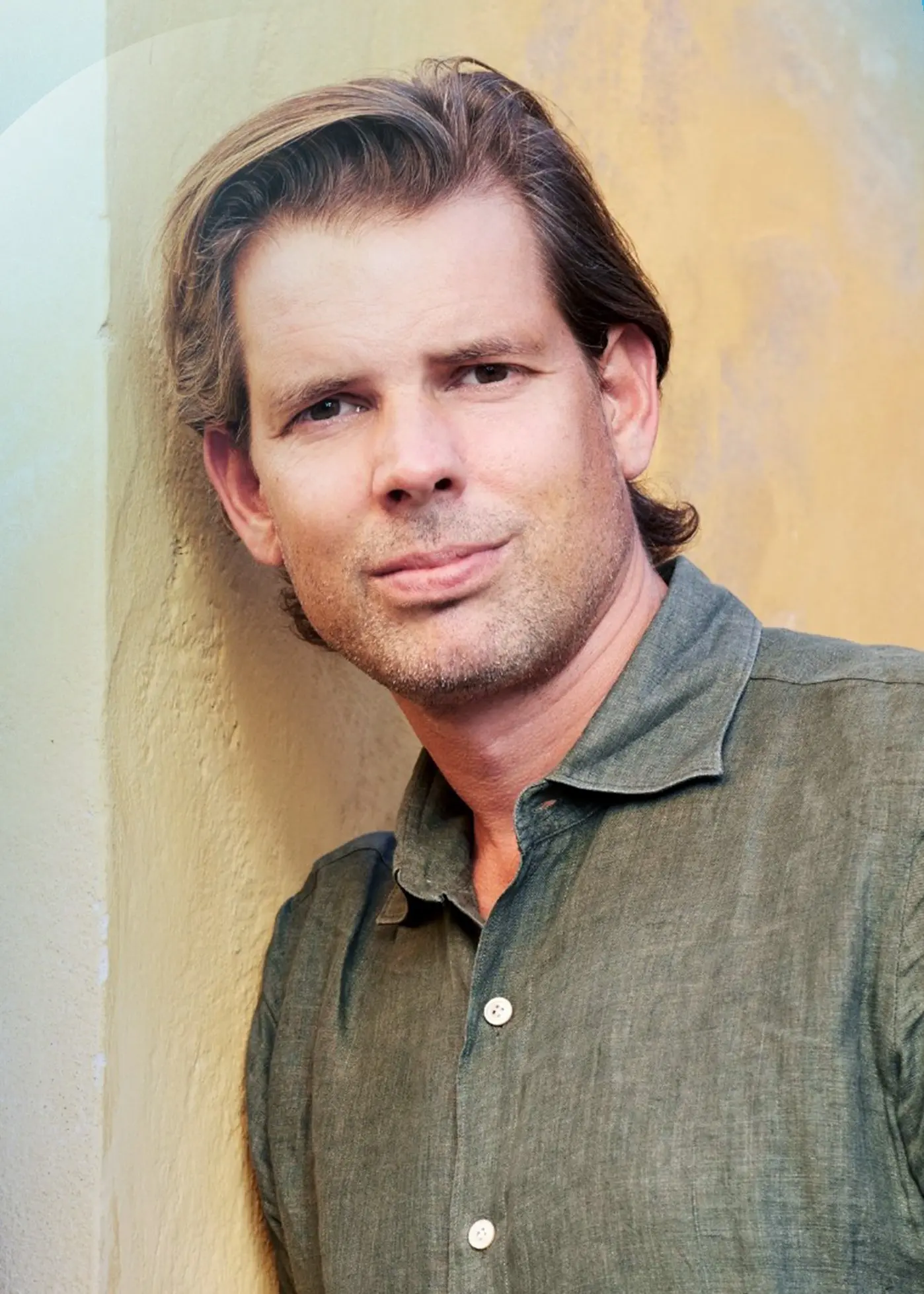 Martin Wicklin och Alex Schulman står mot en ockragul husfasad med ett litet bladverk i högra hörnet 