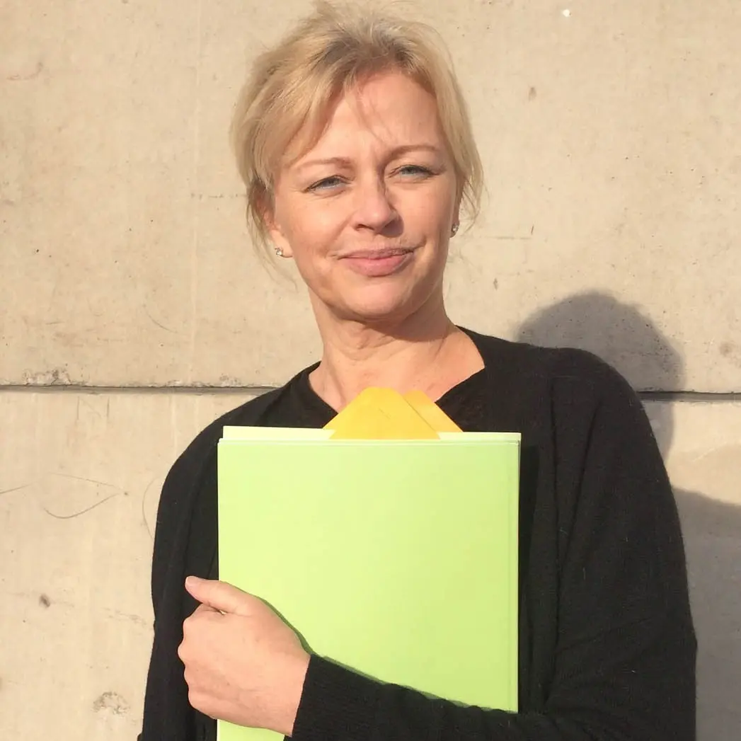 En kvinna till med ett grönt dokument.