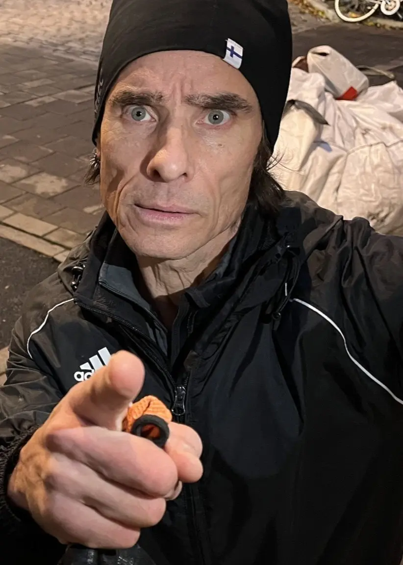 Kändisprofilen Peter Siepen står på en trottoar där det ligger en byggsäck med skräp från ett byggprojekt. Han pekar in i kameran och ser upprörd ut.