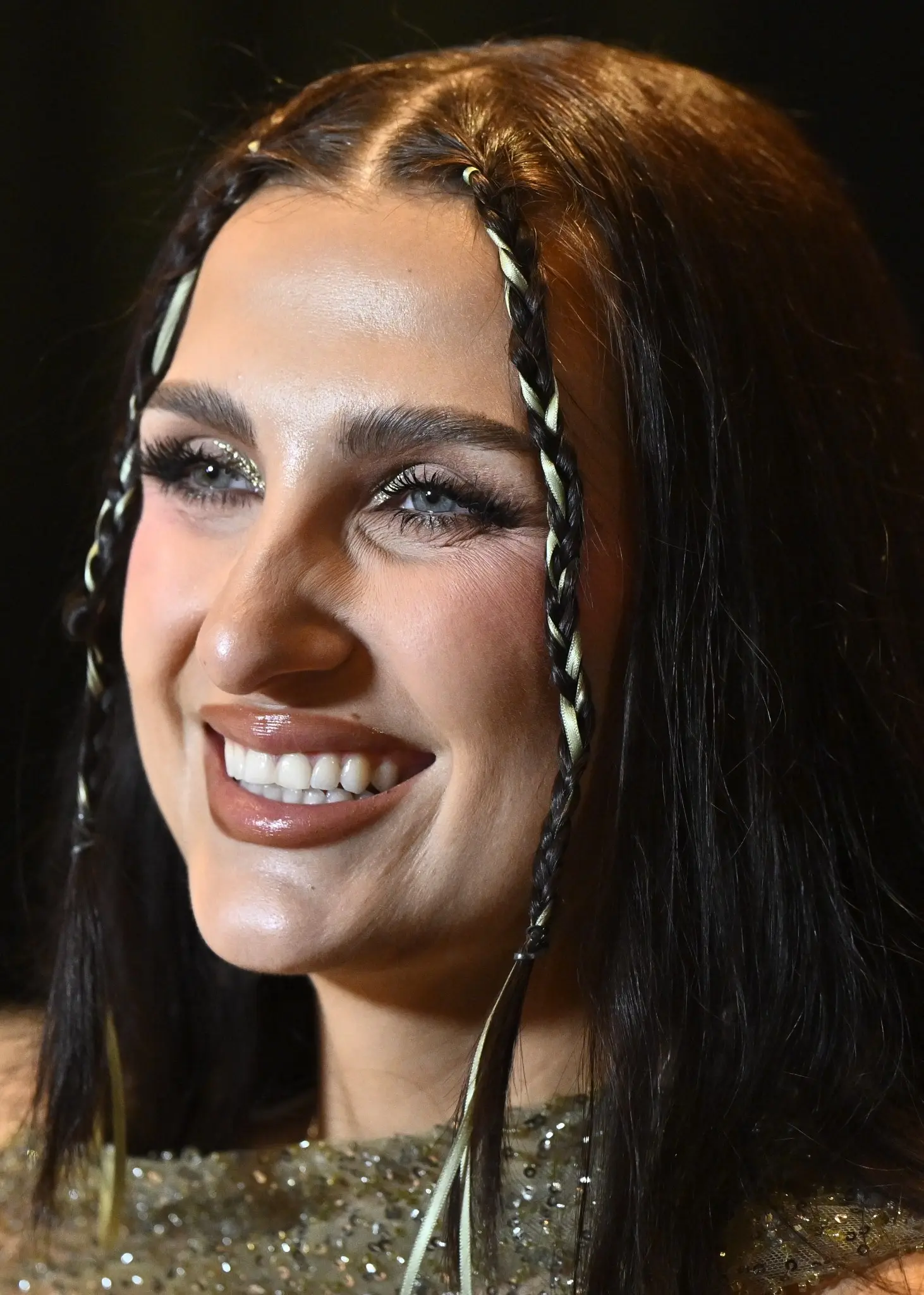 Gruppbild av alla artister som deltar i Melodifestivalen 2026 under en pressträff i Stockholm. De står framför en scen med färgglad belysning och en spegelboll i bakgrunden.