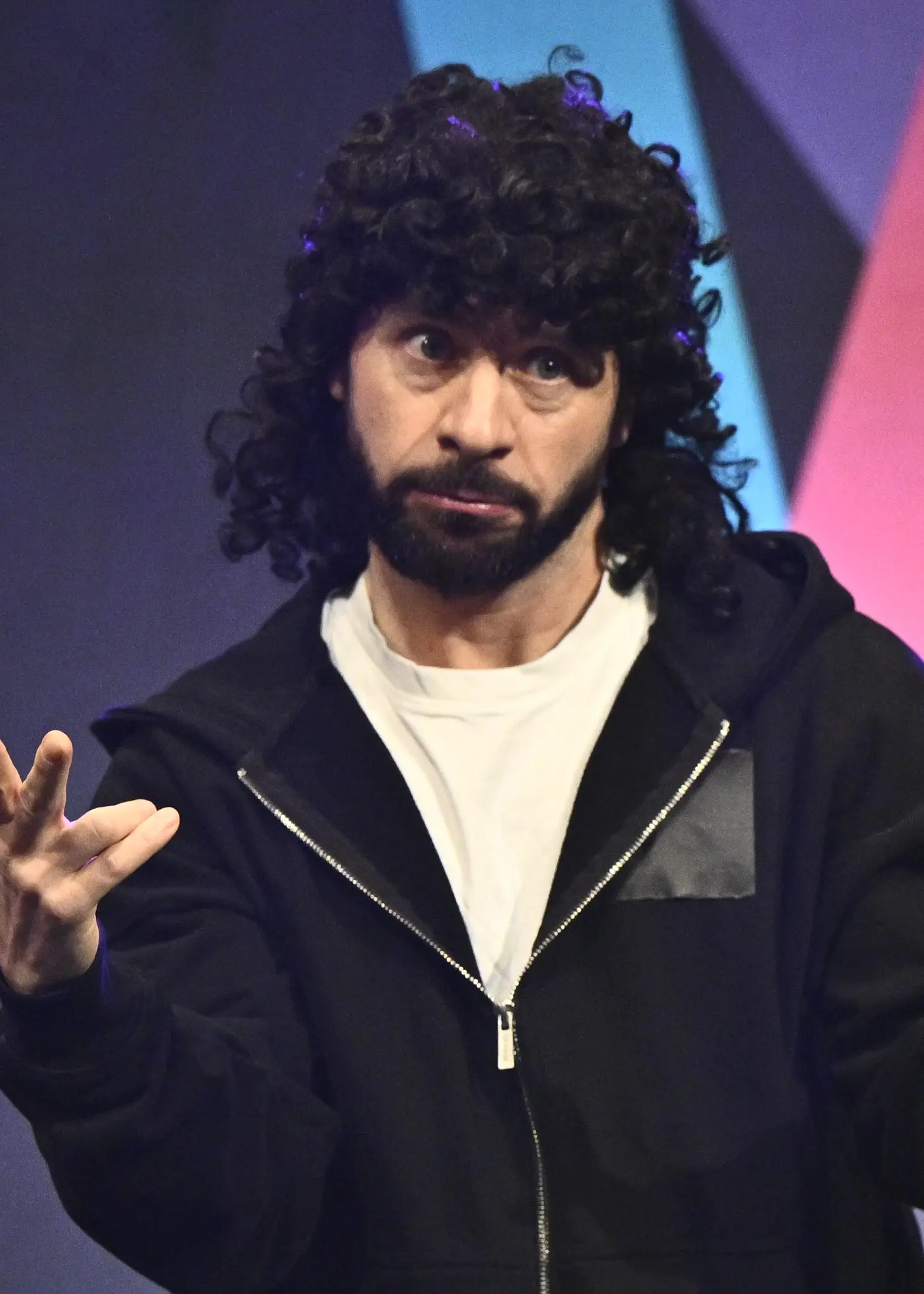 Man i mörk peruk och kvinna i grön jacka.