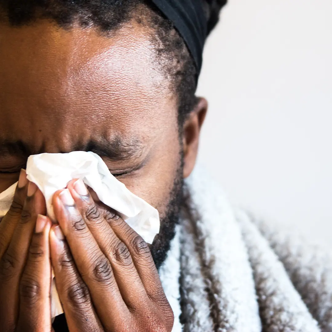 Magnus Gisslén, står i en ljus och modern miljö med stora glaspartier och möbler i bakgrunden.