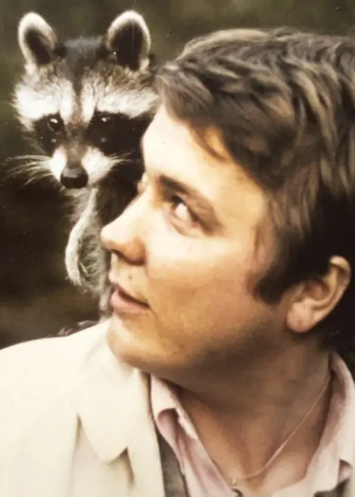 Den lilla tvättbjörnen Pokie sitter på en ung mans axel.