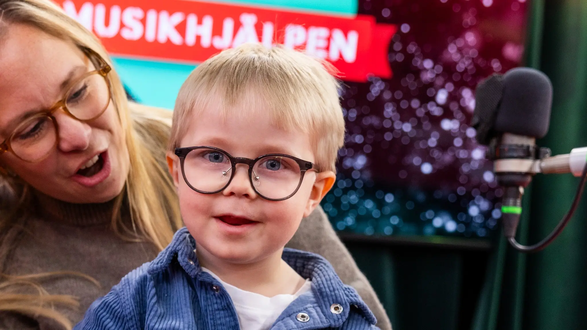 en liten pojke i mammans famn i glasburen under Musikhjälpen i Karlstad