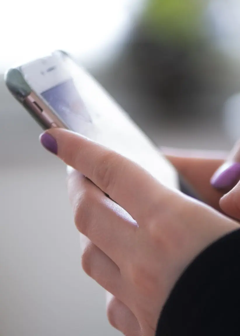 Tonåring håller mobil i handen.