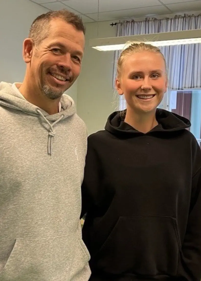 Ronnie Andersson, assisterande tränare, och Lova Jansson, medlem i flicklandslaget i golf, står inomhus. Till höger golfspelare i rosa tröja och vit kjol som svingar en golfklubba.