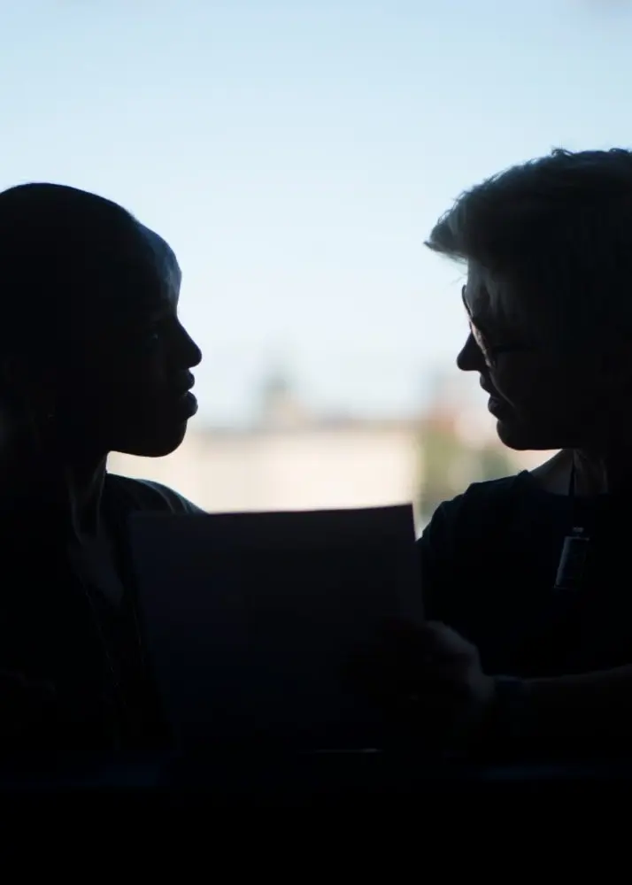 Ett kollage som visar två personer i silhuett som diskuterar med ett dokument. Till höger visas en Sacos ordförande Sofia Rydgren Stale i beige kavaj.