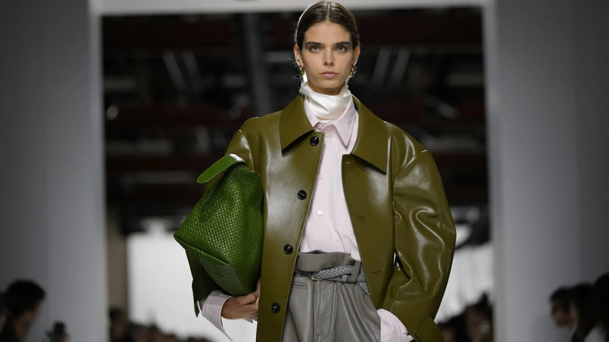 En modell på en catwalk bärande grön väska från Bottega Veneta