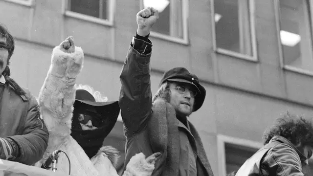 John Lennon och hans fru Yoko Ono lyfter sina knutna nävar när de ansluter till en protest den 5 februari 1972.