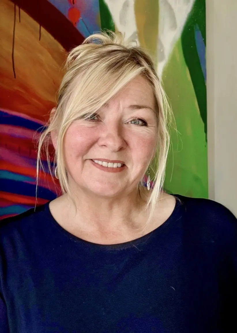 Jeanette Åkerlund står bredvid en vägg med bilder på Ebba.