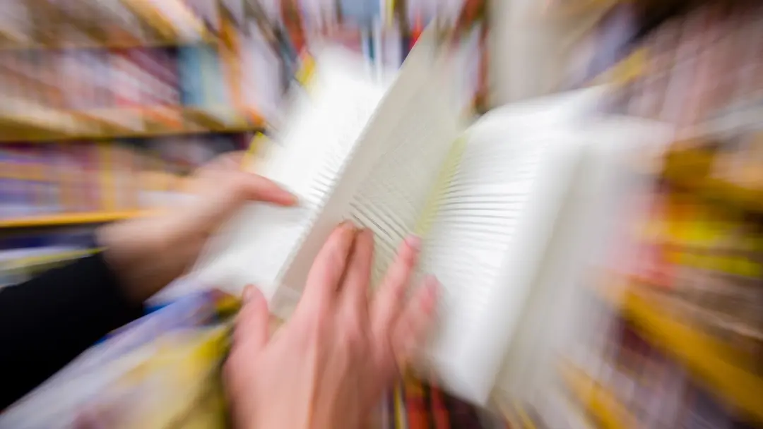 En kvinna håller i en bok i en affär. Hela bilden är suddad och signalerar stress. Foto: Gorm Kallestad/TT