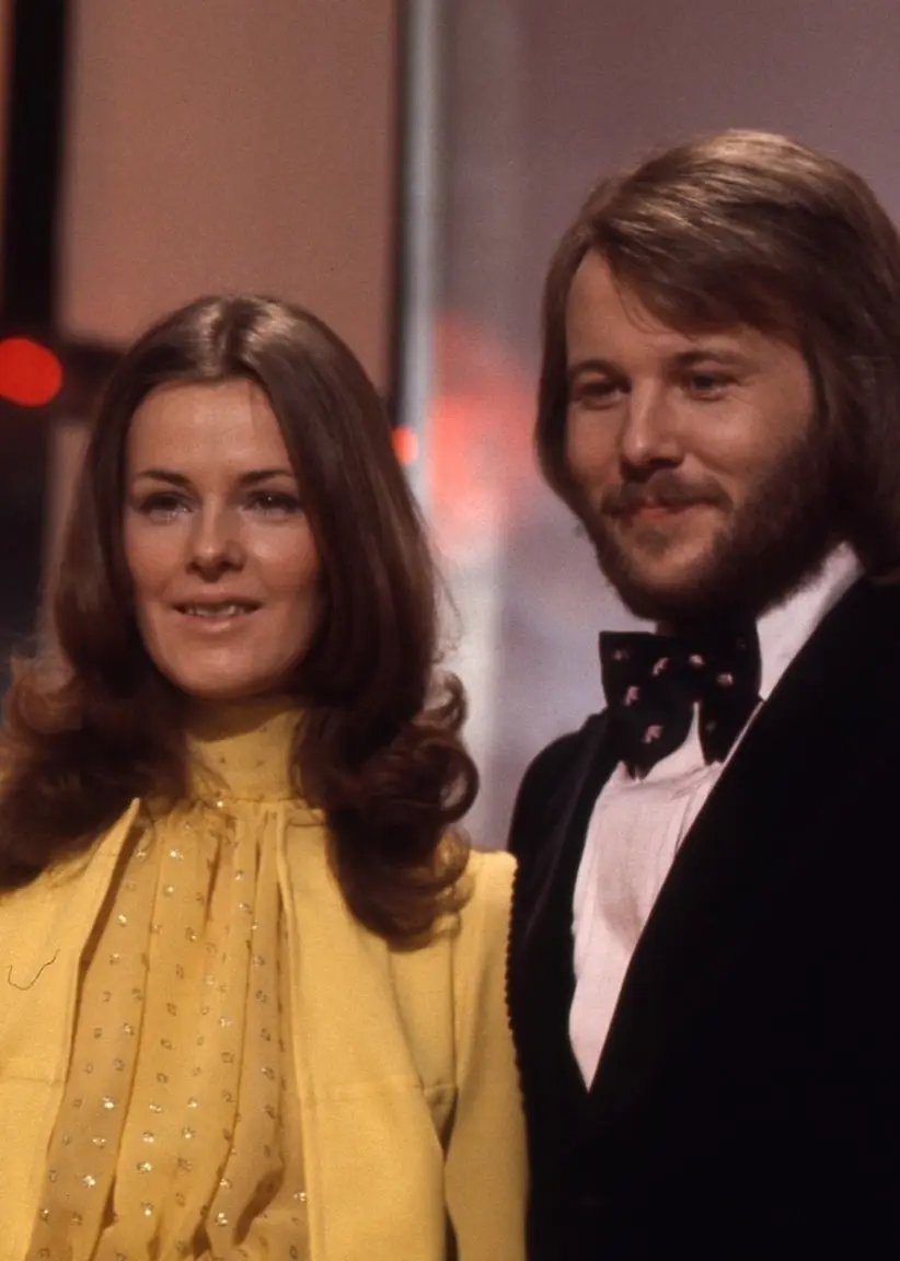ABBA ler mot kameran från Melodifestivalens scen 1973. Björn och Benny har kostym, skjorta och fluga. Agnetha och Frida har långt hår.