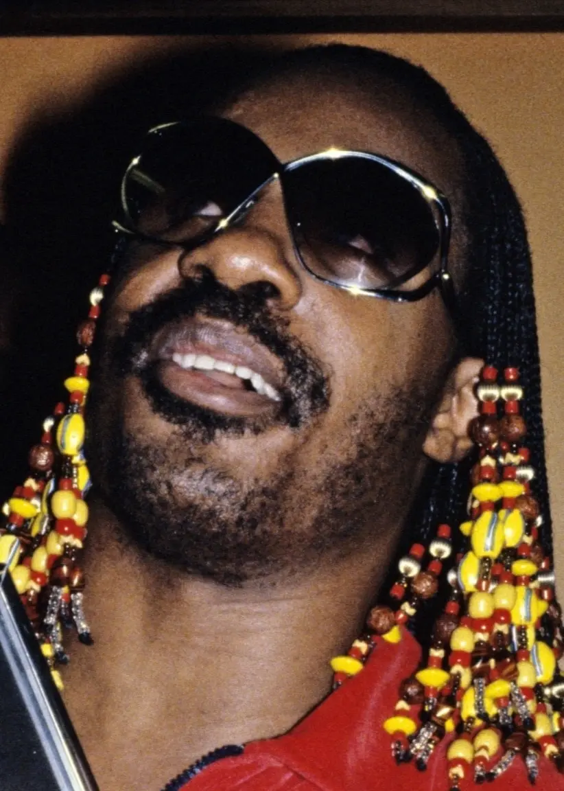 Stevie Wonder i närbild. Han bär svarta solglasögon och har dreads.