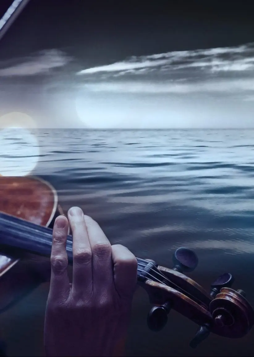 En violinist framför ett hav