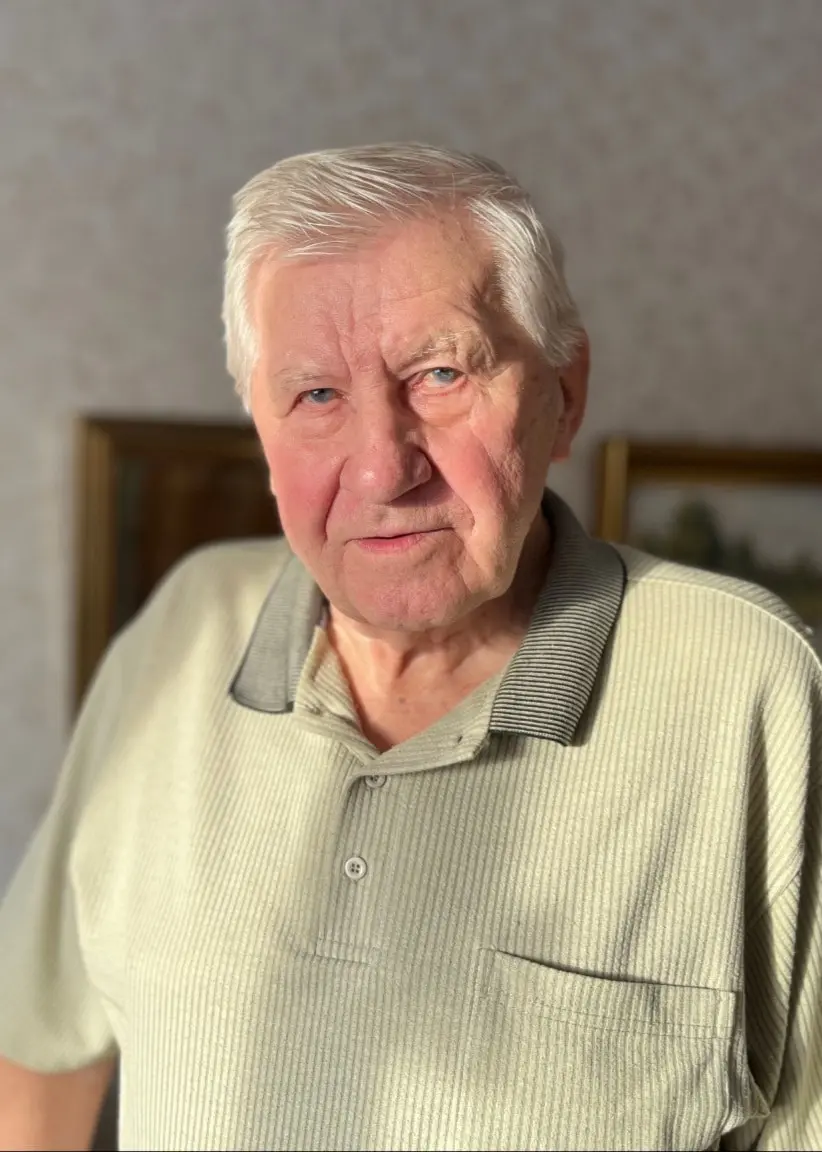 En bild uppdelad i två delar: till vänster syns en äldre man i randig tröja inomhus, till höger en närbild av en svart och grå kaja mot en stenig bakgrund.