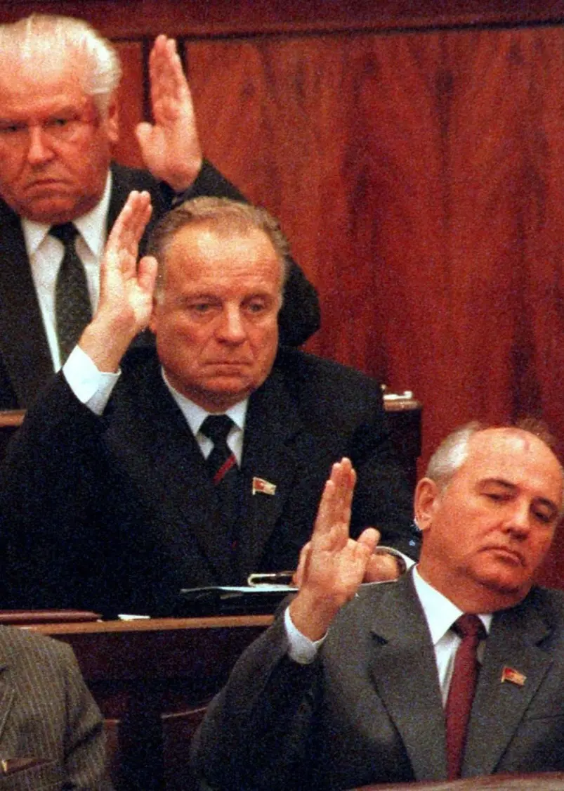 Omröstning i det kommunistiska partiet 1988. På bilden syns 9 medlemmar i partiet. Sju av dem räcker upp handen för att rösta.