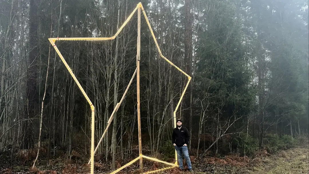 Victor Röjerås står som en liten figur bredvid den 6 meter höga julstjärnan han har byggt.