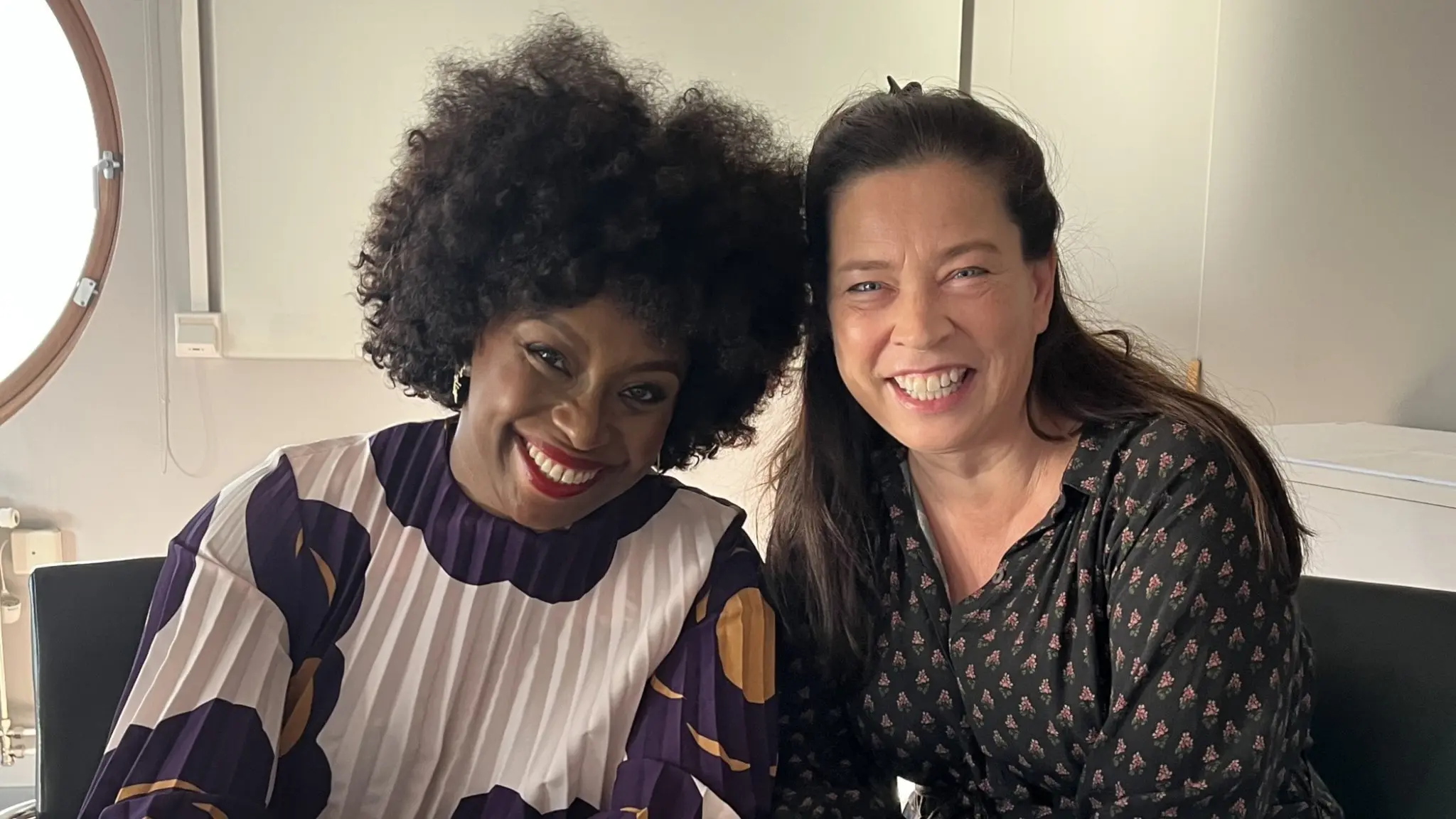 Chimamanda Ngozi Adichie och Marie Lundström sitter bredvid varandra och ler.