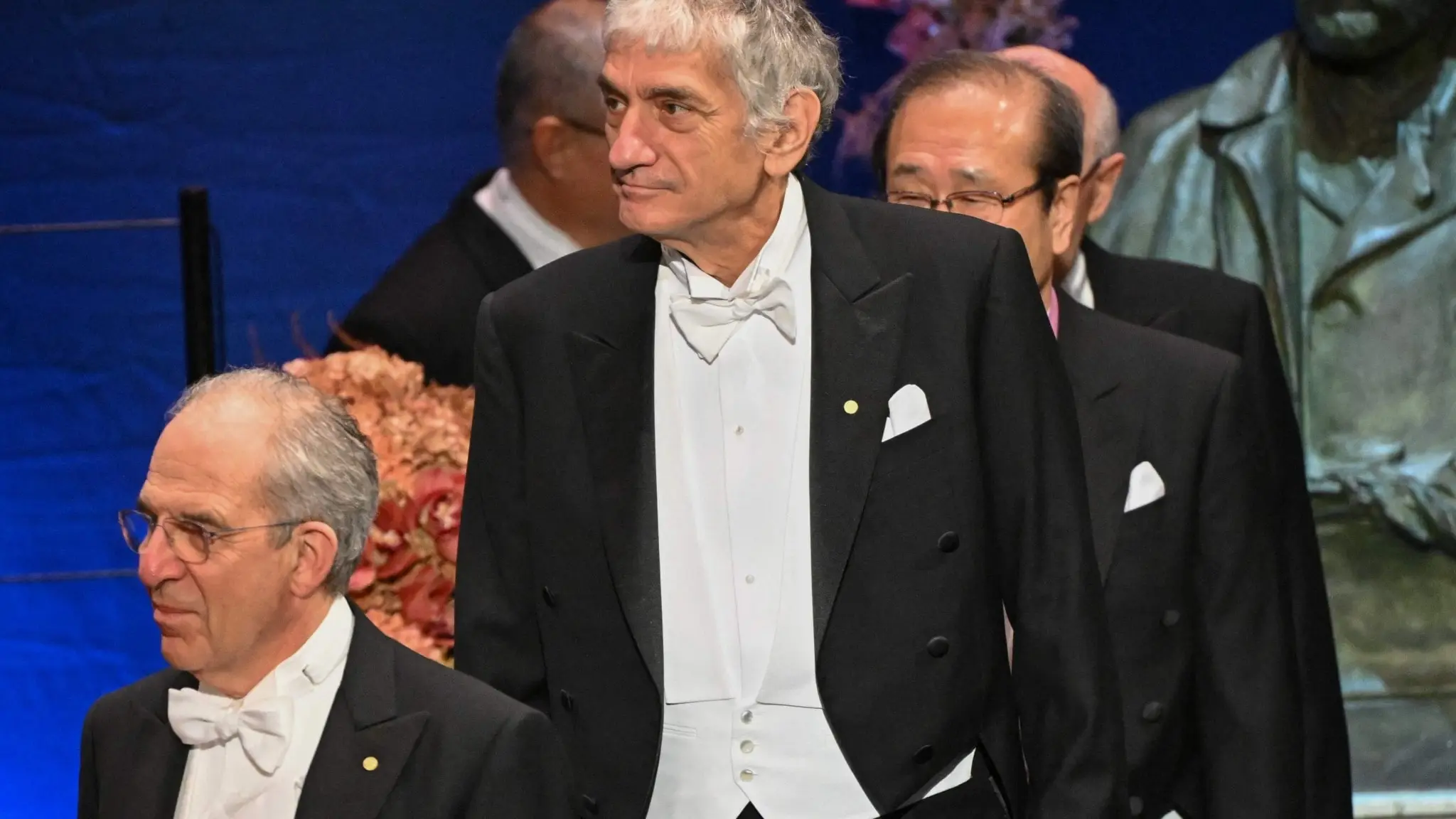 Michel Devoret och John Martinis, fysikpristagare, och andra män i frack bakom dem i parad vid utdelningen av Nobelpriset 2025.