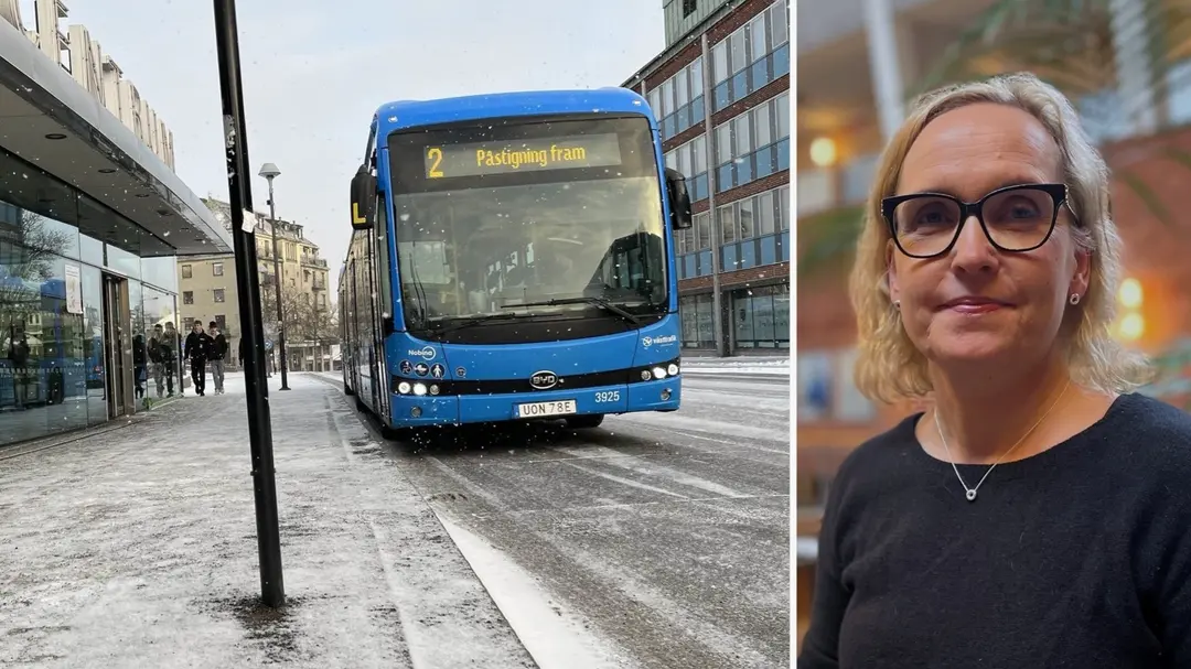 En blå stadsbuss med linjenummer 2 kör på en snöig gata i stadsmiljö, omgiven av byggnader och fotgängare. Helena Ruderfors (C) är med på bilden, i svart tröja och svarta glasögon.
