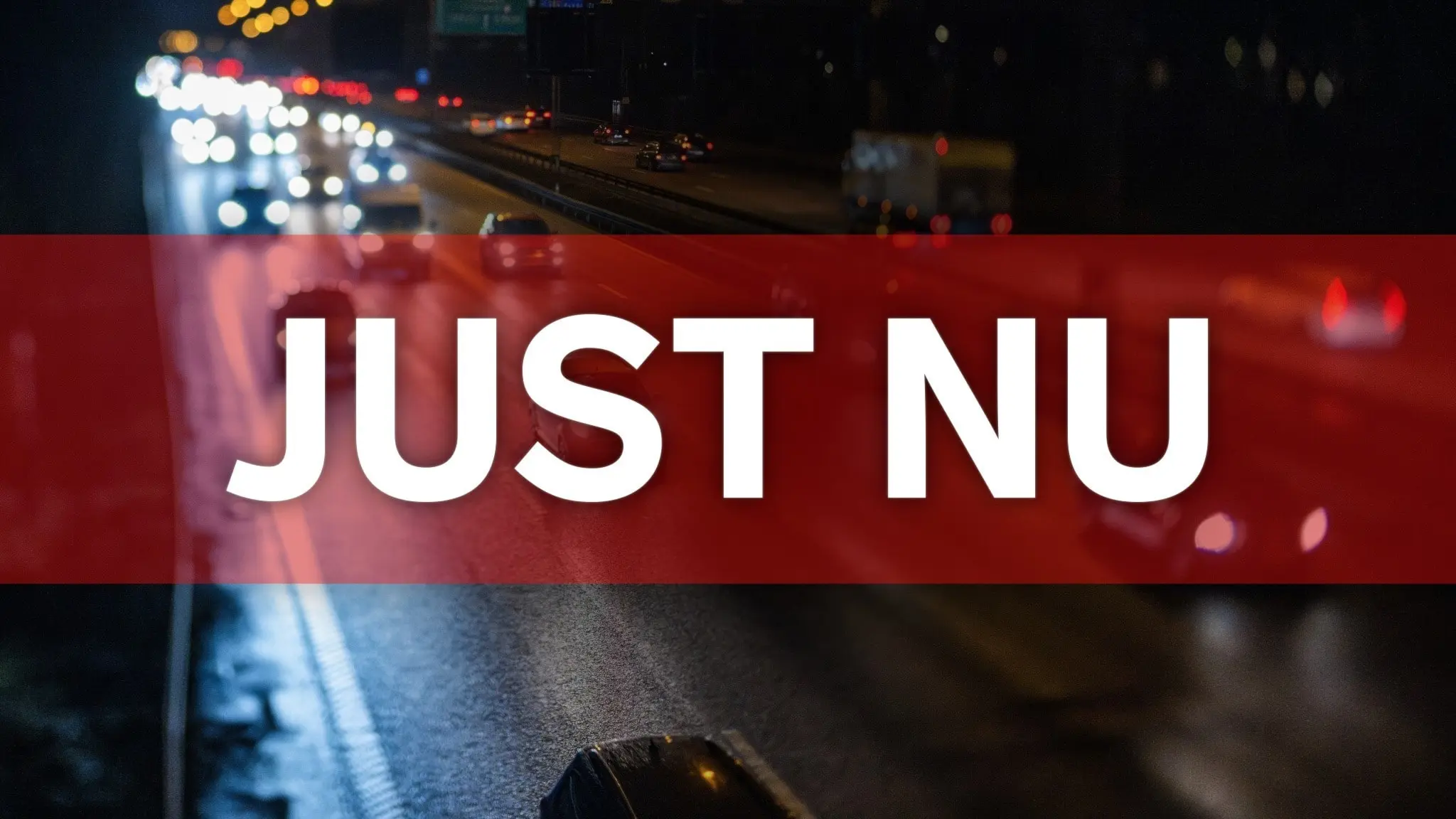 En mörk natt med flera bilar som kör på en stor väg. Ljuset från fordon reflekteras i vägen.