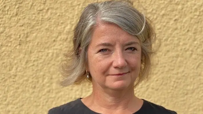 kvinna mot gul vägg 